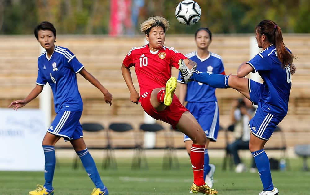 Taiwan's Wang Hsiang Huei, right, and China's Li Ying attack the ball during their match at the 17th Asian Games in Incheon, South Korea.