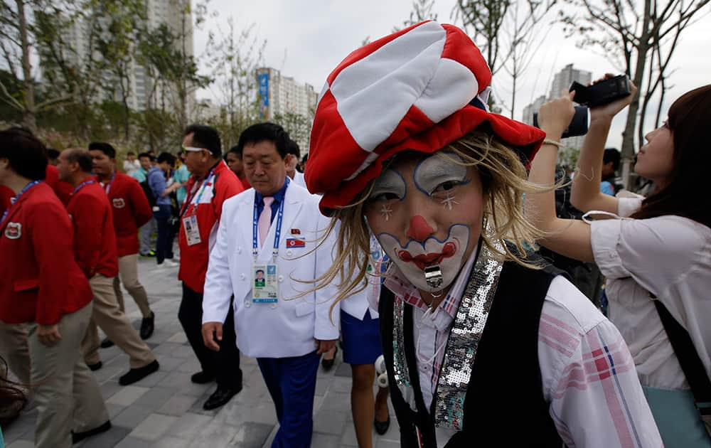 A volunteer with his face painted cheers delegations' arrival for the welcoming ceremony at the Flag Plaza of the Athlete's Village for the 2014 Incheon Asian Games in Incheon, west of Seoul, South Korea.