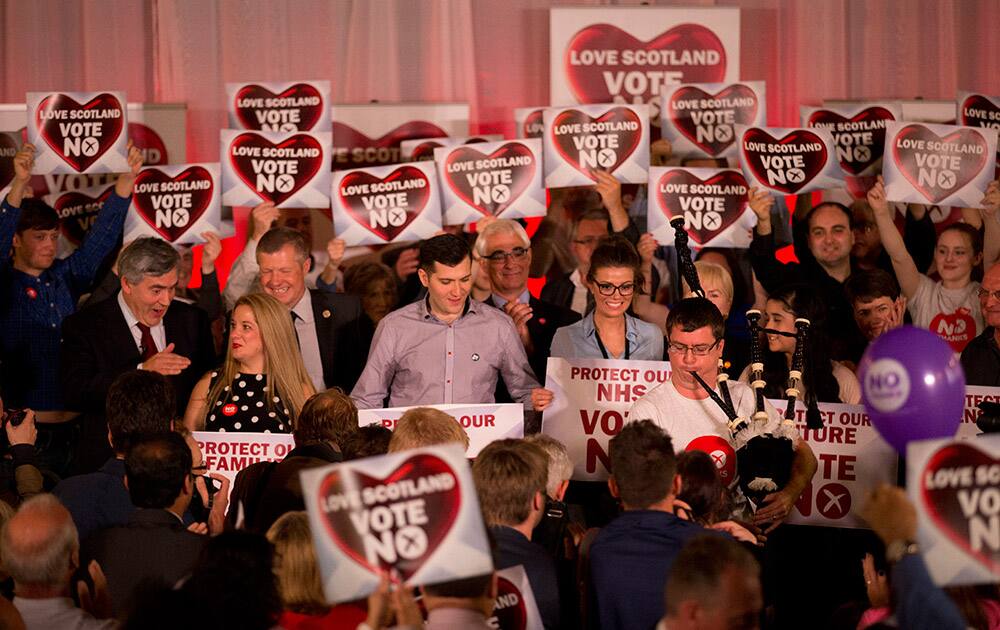 A piper plays at the end of a No campaign event where former British Prime Minister and No campaigner for the Scottish independence referendum Gordon Brown, left middle row gesturing, and other people and politicians made speeches in Glasgow, Scotland.