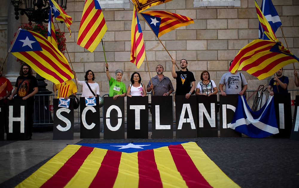 Supporters for the Yes campaign for the Scottish Independence Referendum hold 'estelada' flags, that symbolize Catalonia's independence, during a demonstration in Barcelona , Spain.