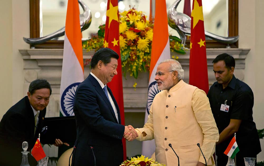 Chinese President Xi Jinping shakes hands with Indian Prime Minister Narendra Modi after signing agreements in New Delhi.