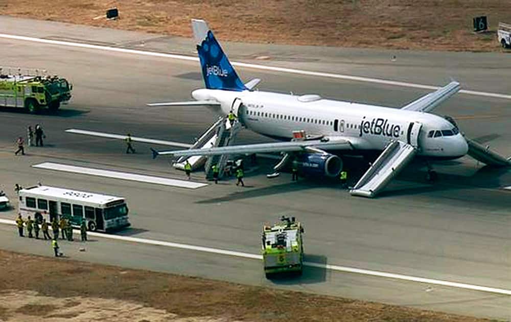 This still frame from video provided by KABC-TV shows a JetBlue airliner on the Long Beach Airport runway with emergency slides deployed in Long Beach, Calif.