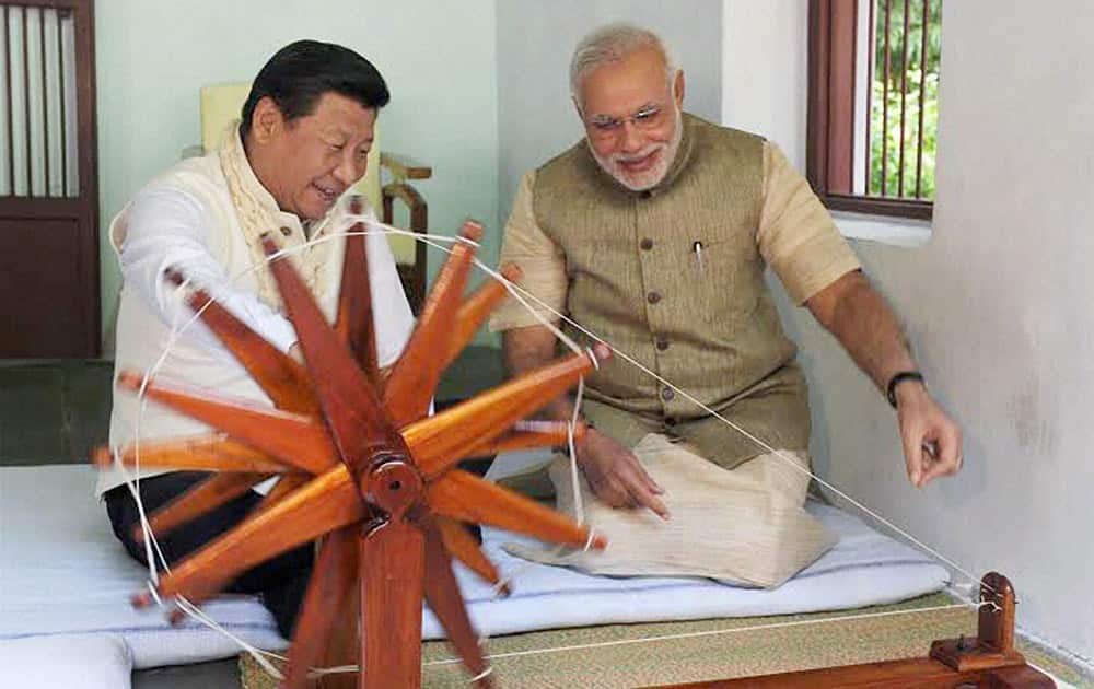 Prime Minister Narendra Modi explains about the working of spinning wheel to Chinese President Xi Jinping at Gandhi Ashram in Ahmedabad.