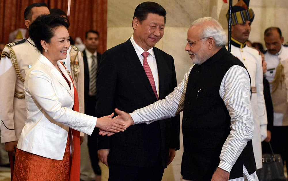 Prime Minister Narendra Modi shakes hands with Chinese first lady Peng Liyuan as Chinese President Xi Jinping looks on during a banquet at Rashtrapati Bhavan in New Delhi.