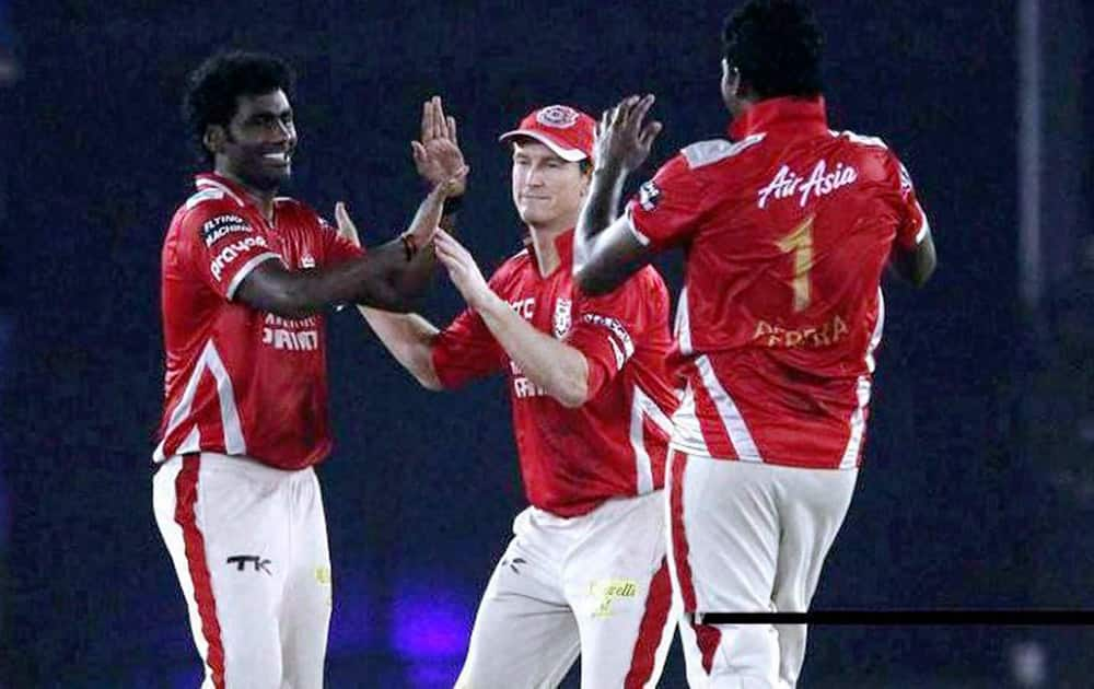 Kings XI Punjabs bowler Parvinder Awana (L) celebrate with captain George Bailey and Thisara Perera after taking wicket of Hobart Hurricanes batsman Aiden Blizzard during the Champions League Twenty20 match at Mohali