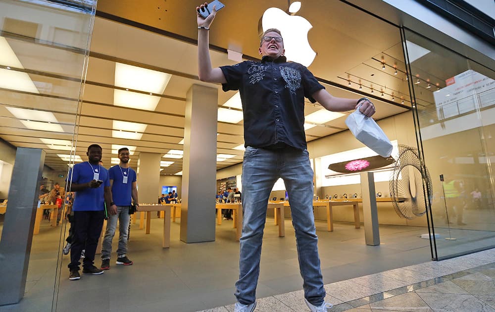 First customer Max, 20, jumps in joy with new mobile phones in his hands during the launch of the Apple iPhone 6 sale at a store in Oberhausen, Germany.