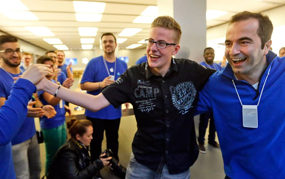 First customer Max, 20, is welcomed by Apple employees during the launch of the Apple iPhone 6 sale at a store in Oberhausen, Germany.