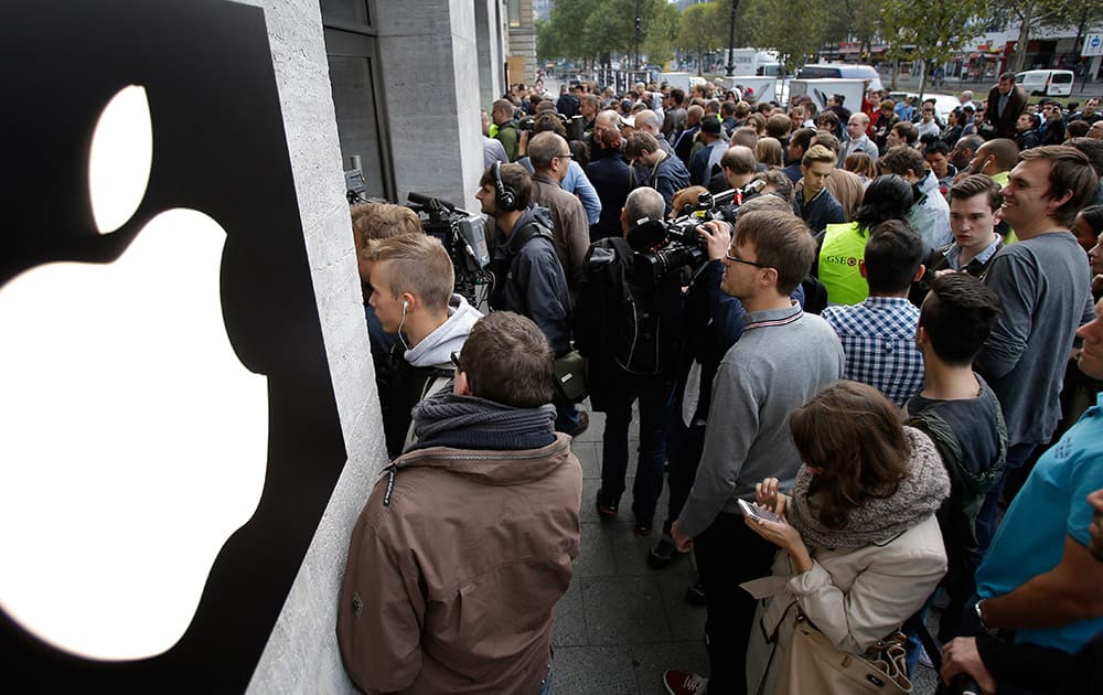 People queue in front of the Apple store to buy the new iPhone in Berlin, Germany.