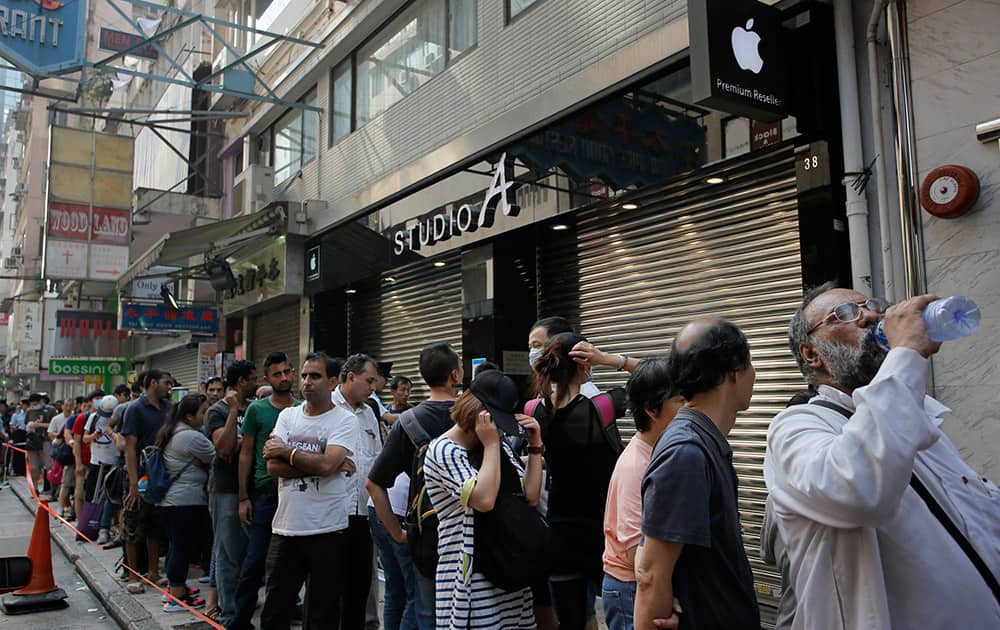 People wait to buy the new Apple iPhone 6 and 6 Plus devices, outside an Apple premium reseller store in Hong Kong. The iPhone 6 and 6 Plus were released on Friday in Hong Kong.