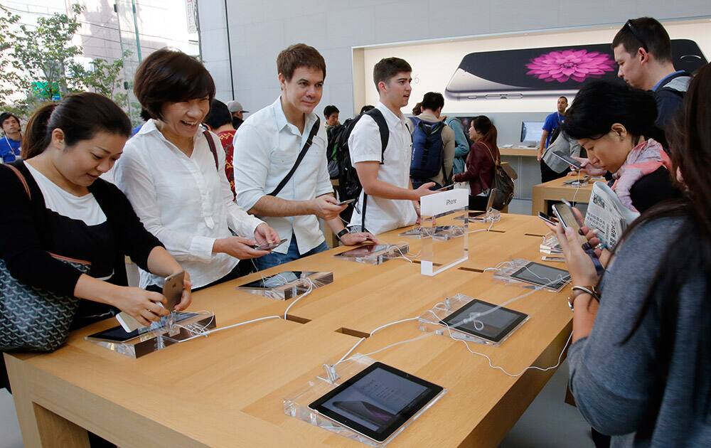 Customers try the new Apple iPhone 6 and 6 Plus at a store in Tokyo.