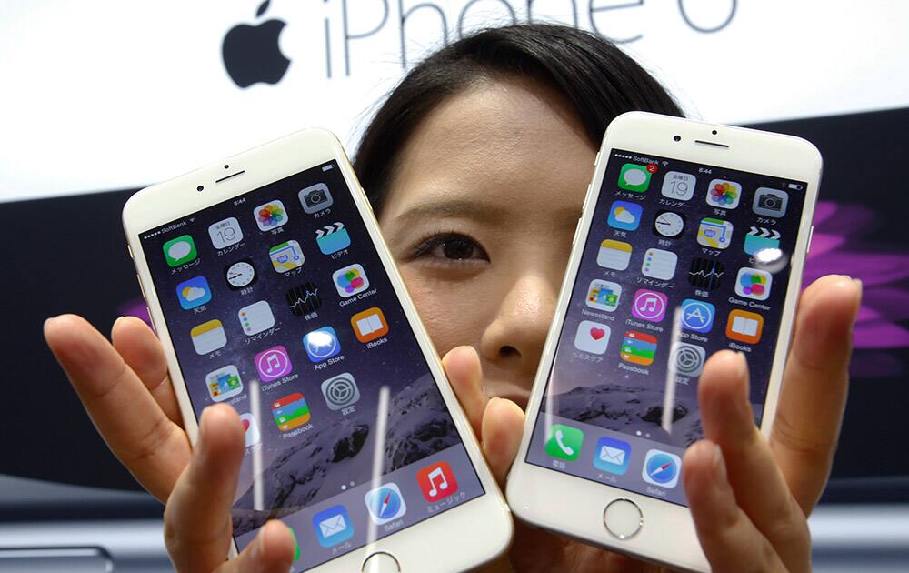 A customer shows off the new Apple iPhone 6 and 6 Plus at a store in Tokyo.