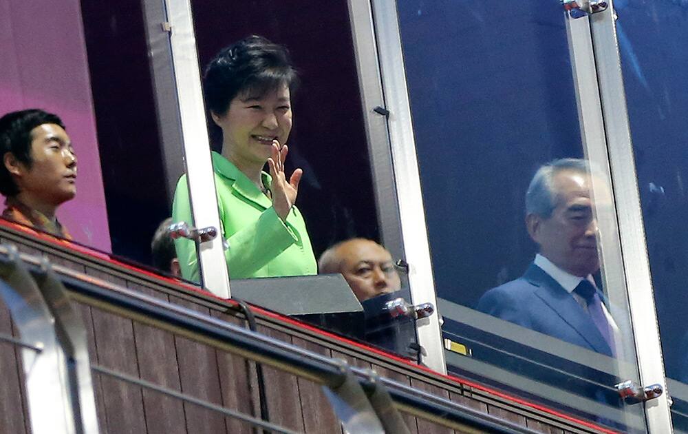 South Korean President Park Geun-hye, 2nd left, waves as she watches the national flag rising during the opening ceremony for the 17th Asian Games at Incheon Asiad Main Stadium in Incheon, South Korea.