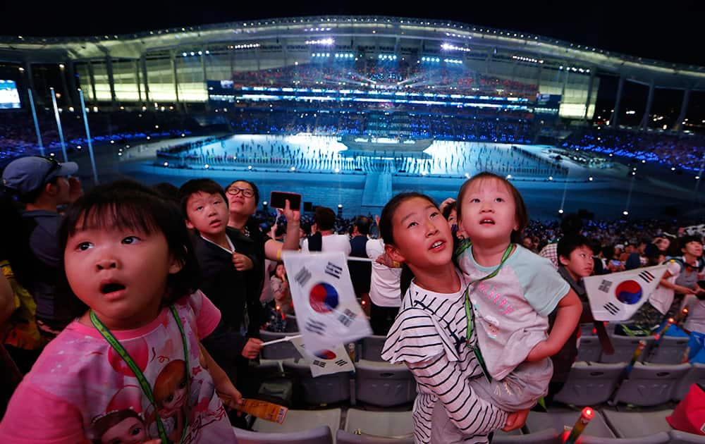 Young visitors watch video screens during the opening ceremony for the 17th Asian Games in Incheon, South Korea.