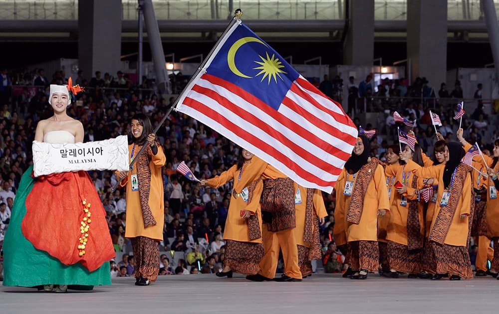 Members of the Malaysian delegation wave their national flag and walk into the stadium during the opening ceremony for the 17th Asian Games in Incheon, South Korea.