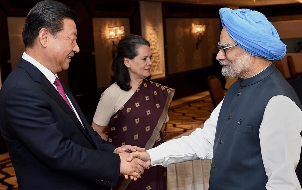 Former Prime Minister Manmohan Singh shakes hands with Chinese President Xi Jinping before their meeting in New Delhi.