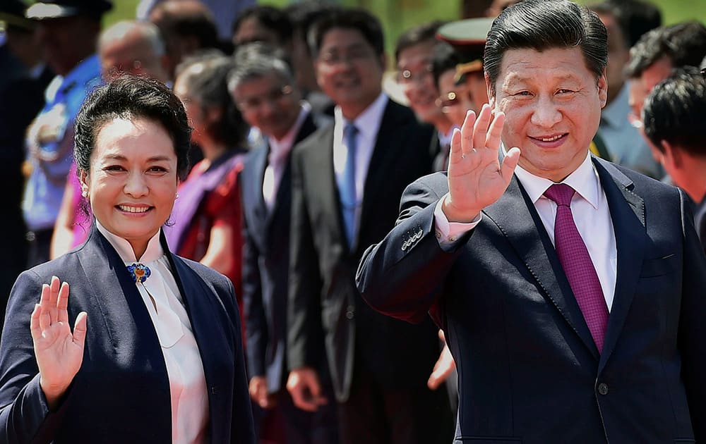 Chinese President Xi Jinping, with his wife Peng Liyuan wave before their departure, in New Delhi.
