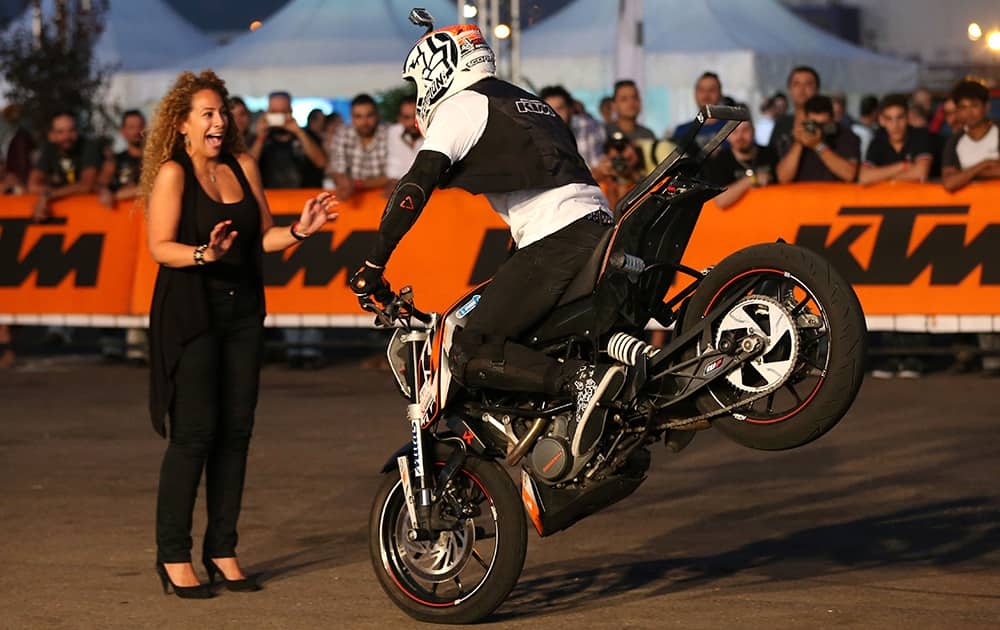 Slovenian KTM stunt rider Rok Bagoros performs on his motorcycle in front of a Lebanese TV reporter during the Beirut Bike Festival, at Beirut waterfront, Lebanon.