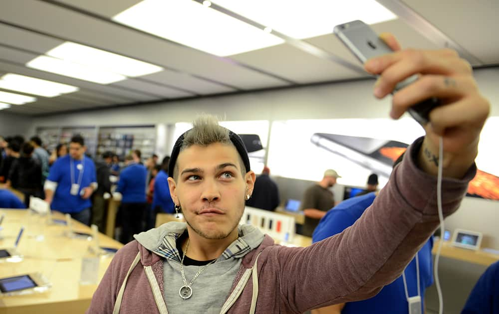 Dani Winters poses as he takes a selfie with a new iPhone at the iPhone 6 launch at the Eaton Centre Apple Store, in Toronto.