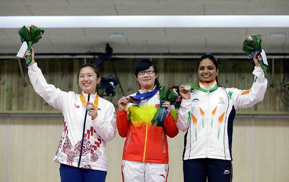 Winner China's Mengyuan Zhang, center, silver medalist South Korea's Jung Jee-hae, left, and bronze medalist India's Shweta Chaudhry pose for the media during the medal ceremony for the 10m Air Pistol Women at the Ongnyeon International Shooting Range for the 17th Asian Games in Incheon, South Korea