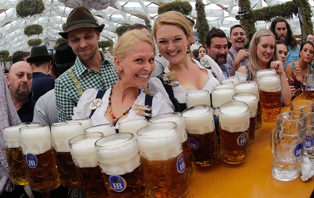 Waitresses Beli, right, and Anika pose with beer mugs during the opening of the 181th Oktoberfest beer festival in Munich, southern Germany.