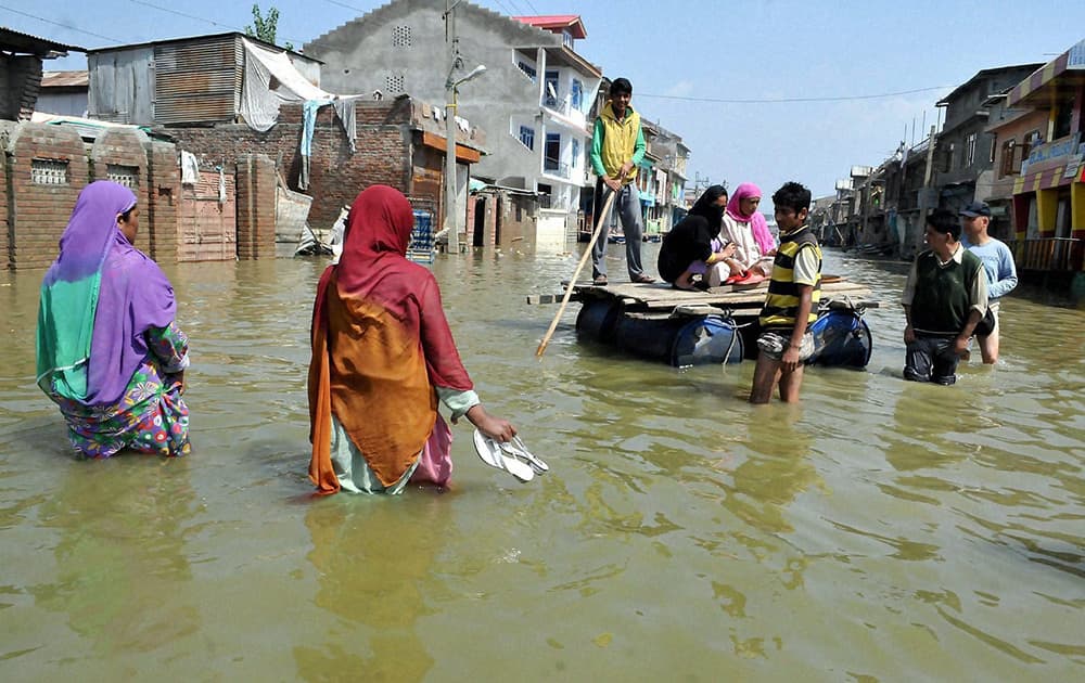 People shifting from a flooded locality on the outskirts of Srinagar.