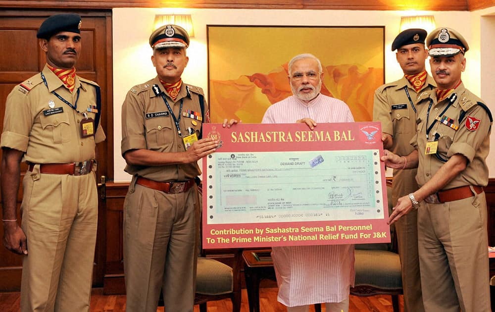 Director General, Sashastra Seema Bal, BD Sharma handing ove a demand draft to Prime Minister Narendra Modi of Rs 2.12 crore towards the Prime Ministers National Relief Fund for flood-affected people of Jammu and Kashmir, in New Delhi.