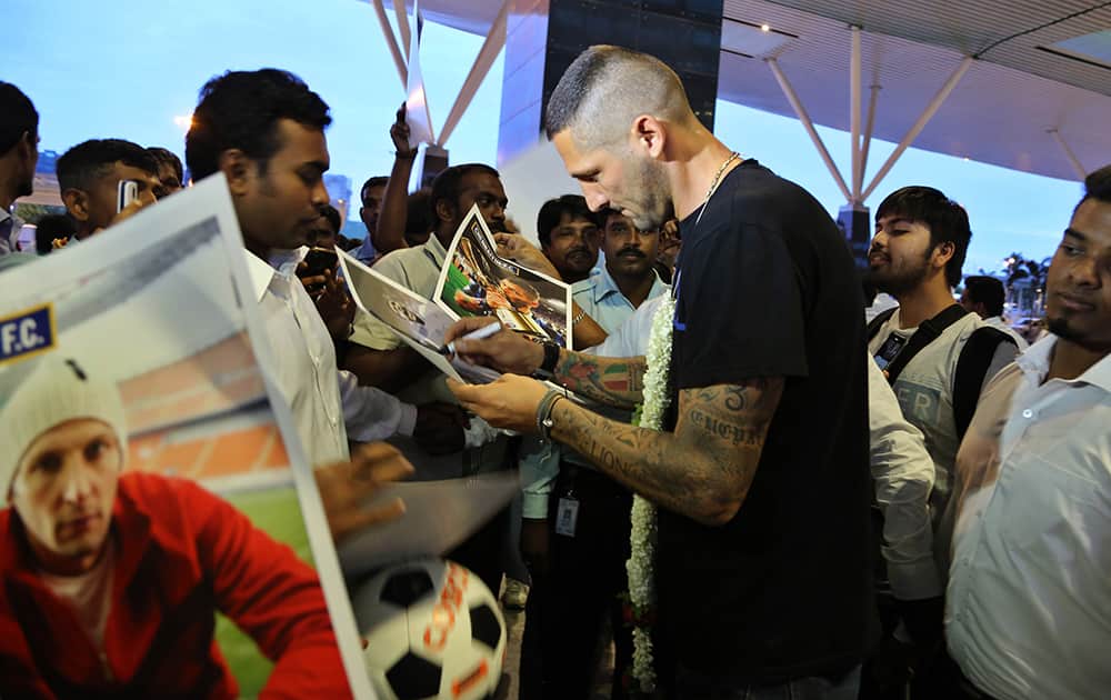 Former Italian football player Marco Materazzi signs autographs for his fans on his arrival in Bangalore.
