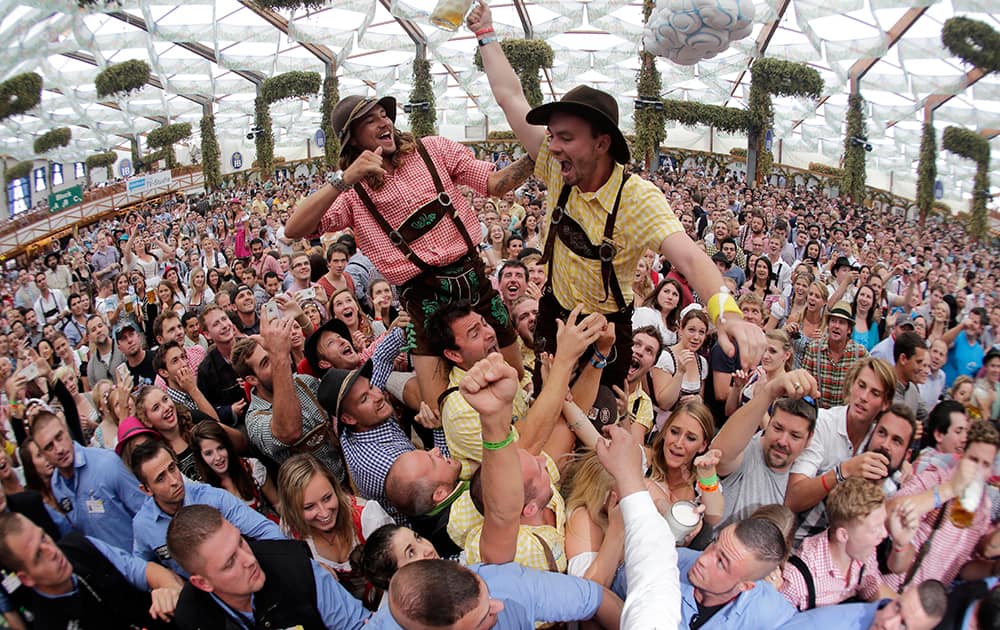 In this photo taken with a fisheye lens, people celebrate the opening of the 181th Oktoberfest beer festival in Munich, southern Germany.