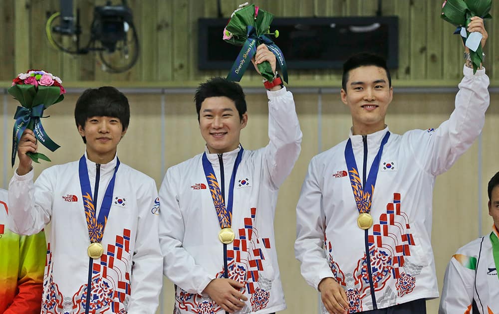Gold medalists, from left to right, Kim Cheong-yong, Jin Jong-oh and Lee Daem-yung celebrate during the victory ceremony for the Men's 10m Air Pistol Team shooting competition at the 17th Asian Games at Ongnyeon International Shooting Range in Incheon, South Korea.