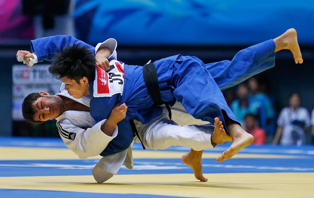 Japan's Toru Shishime, (blue dress), competes with Uzbekistan's Sharafuddin Lutfillaev during men's Judo -60-kilogram bronze medal match at the 17th Asian Games in Incheon, South Korea.