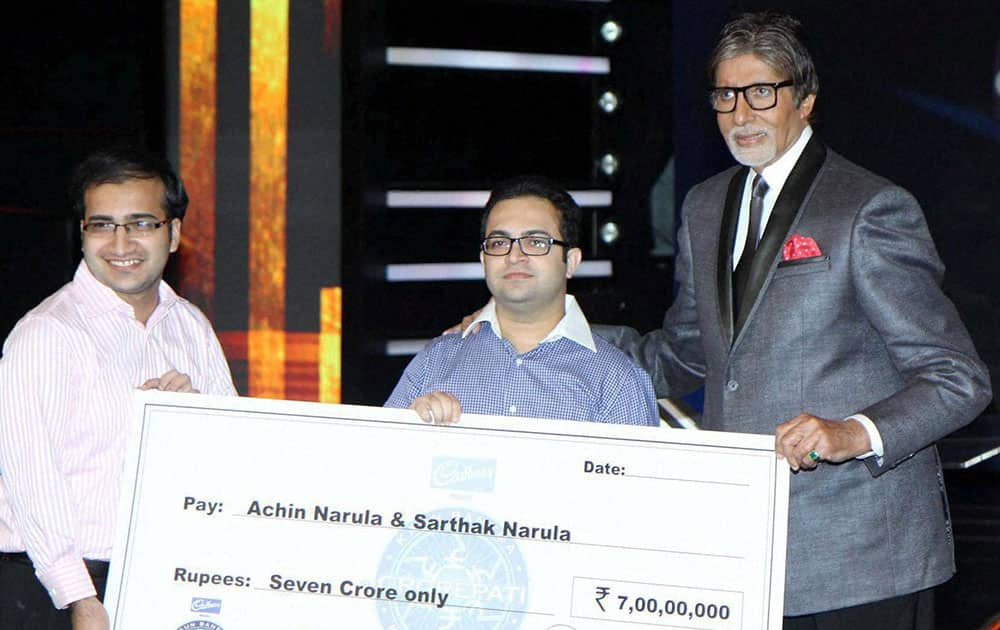 Bollywood actor Amitabh Bachchan presenting the cheque of rupees seven crore to Achin Narula & Sarthak Narula, the first crorepati of this season of KBC in Mumbai.