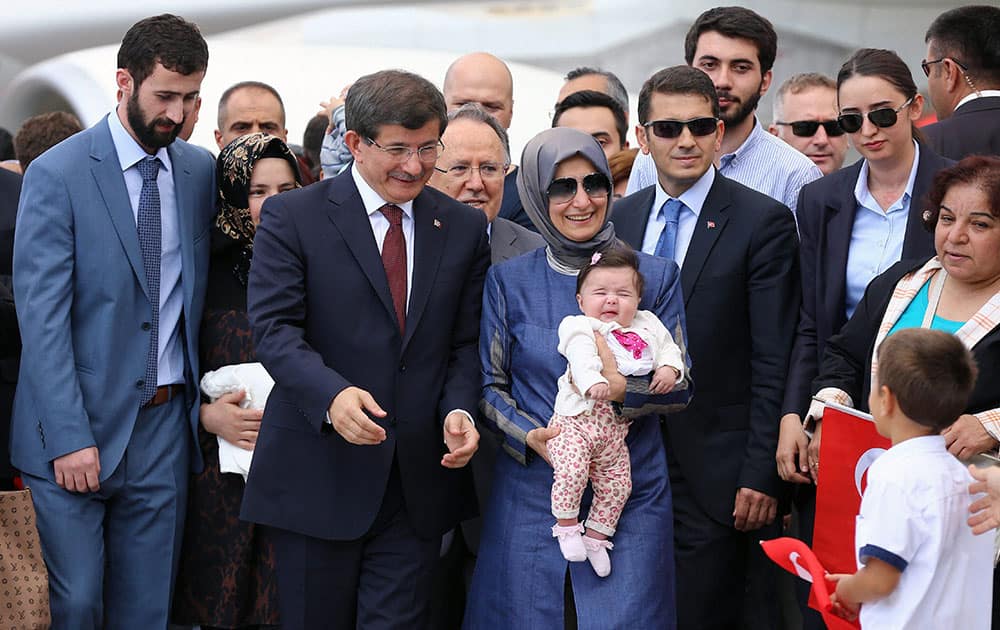 Turkish Prime Minister Ahmet Davutoglu, center left, stands with freed hostages at the airport. Dozens of Turkish hostages seized by Islamic militants in Iraq three months ago.