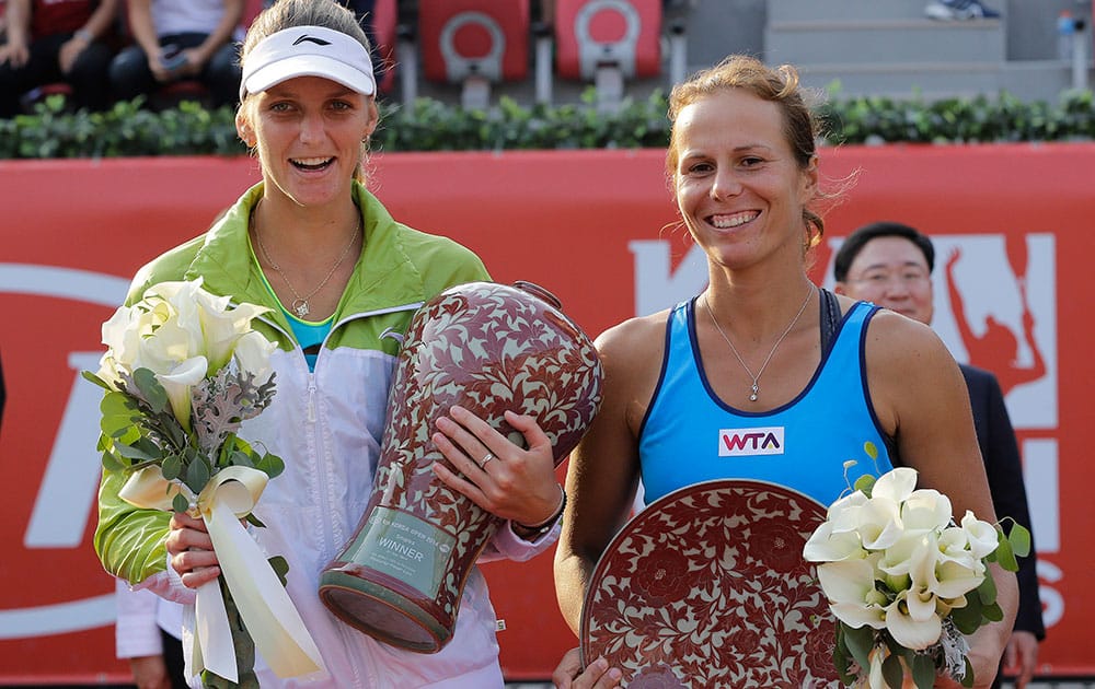 Karolina Pliskova, left, of Czech Republic holds the winner's trophy as Varvara Lepchenko of the United States holds the second placed trophy at the final match of the Korea Open tennis in Seoul.