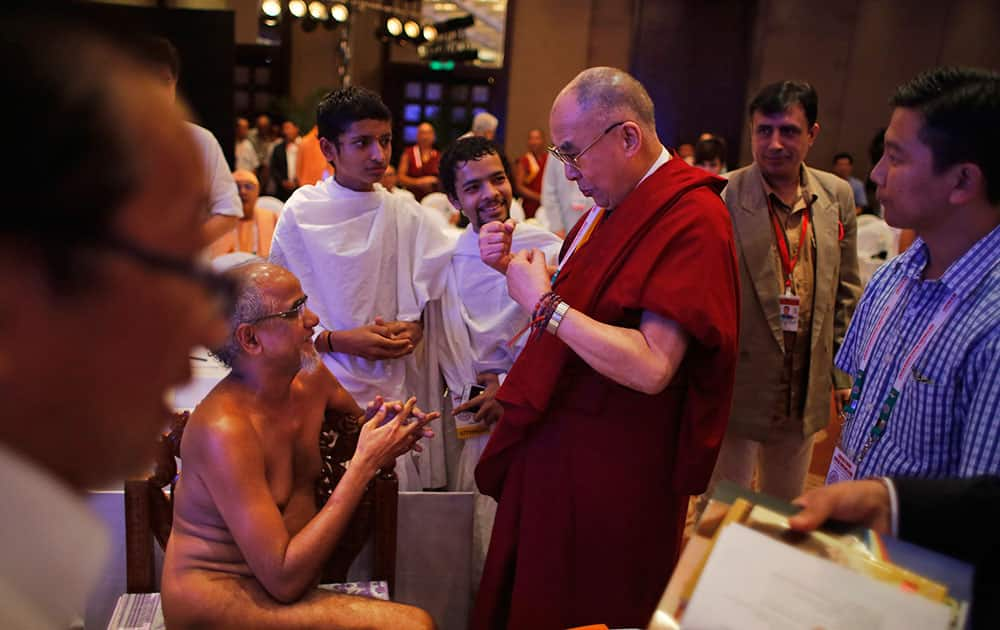 Tibetan spiritual leader the Dalai Lama, center, gestures as he speaks to Munishree Tarun Sagar, sitting, who represents the Digambar sect of Jainism, on the final day of an interfaith meeting in New Delhi, India.