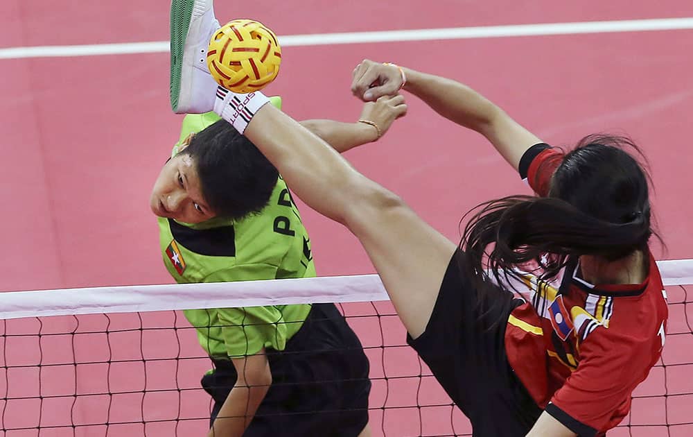 Myanmar's Phyu Phyu Than, left, heads a ball as Laos's Koy Xayavong, right, blocks during the women's doubles sepak takraw final match at the 17th Asian Games in Incheon, South Korea. 