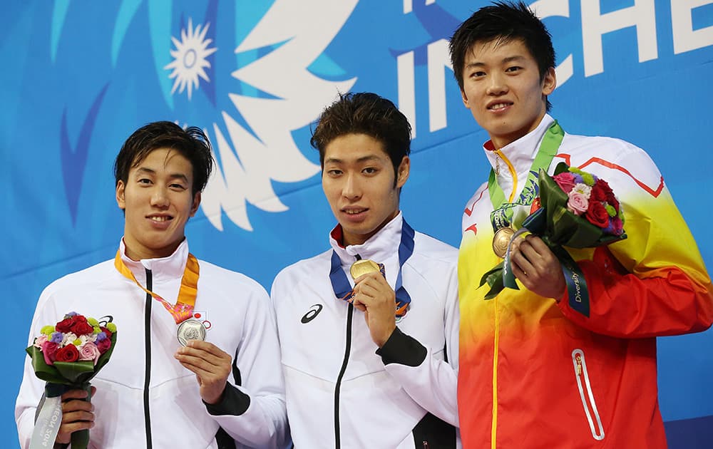 Men's 200-meter individual medley medalists from left, Japan's Hiromasa Fujimori, silver, and his compatriot Kosuke Hagino, gold, and bronze China's Wang Shun pose for a photo on the podium at the 17th Asian Games in Incheon, South Korea.