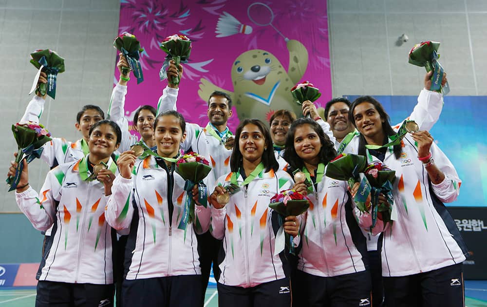 India's team members celebrate after winning the bronze medal of women's team Badminton competition for the 17th Asian Games at the Gyeyang Gymnasium in Incheon, South Korea.