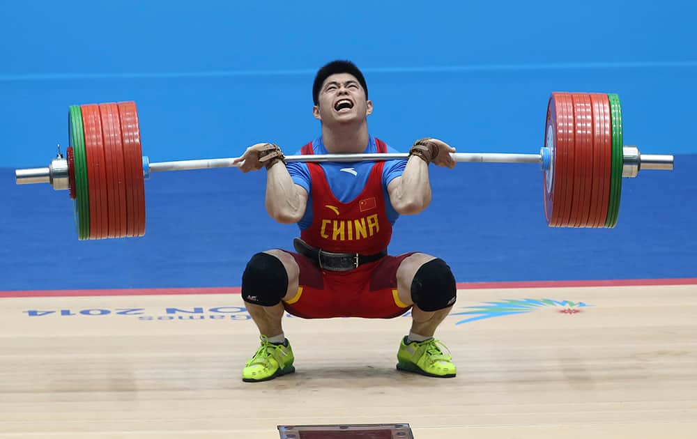 China's Lin Qing Feng attempts a lift during the men's 69kg weightlifting competition at the 17th Asian Games in Incheon, Korea.
