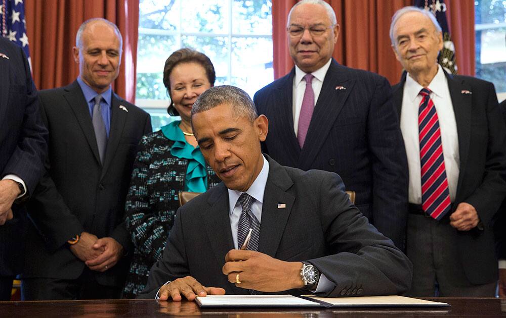 President Barack Obama signs the America's Promise Summit Declaration, in the Oval Office of the White House in Washington. 