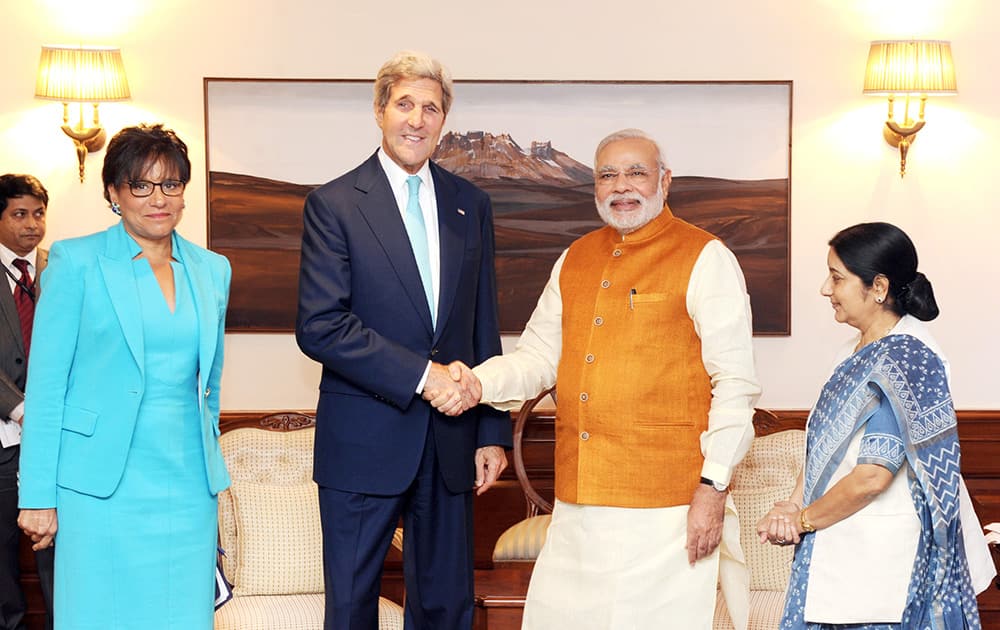 Prime Minister Narendra Modi poses for a photo with US Secretary of State John Kerry, as External Affairs Minister Sushma Swaraj looks on.