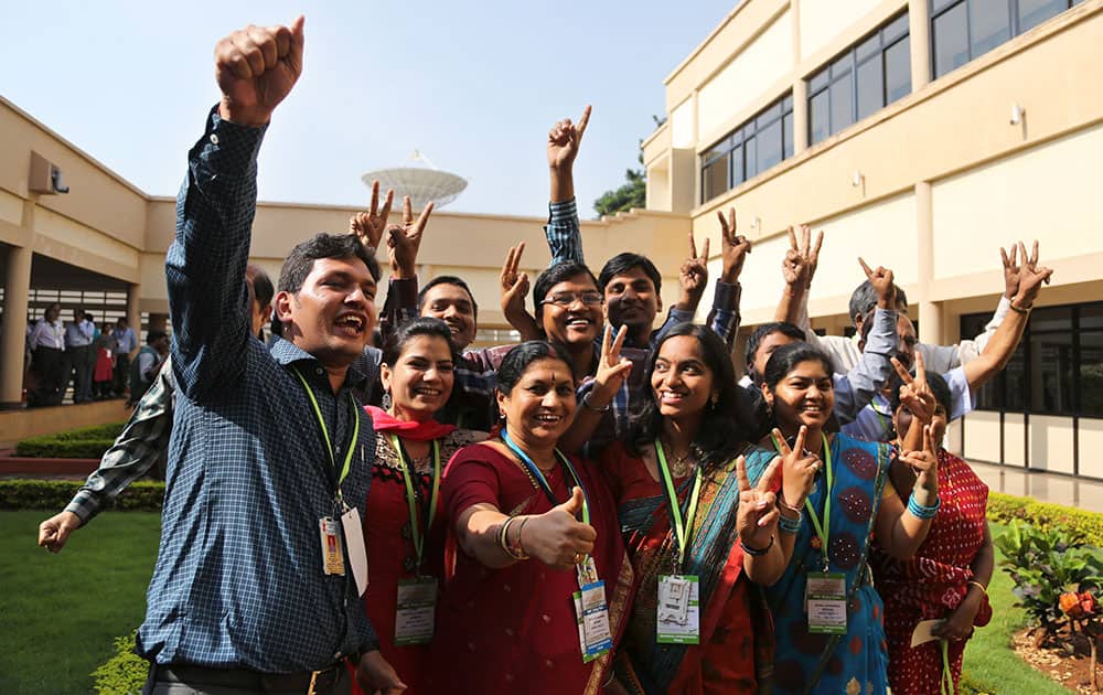 Indian Space Research Organisation scientists and officials pose for photos as they celebrate the success of Mars Orbiter Mission at their Telemetry, Tracking and Command Network complex in Bangalore.