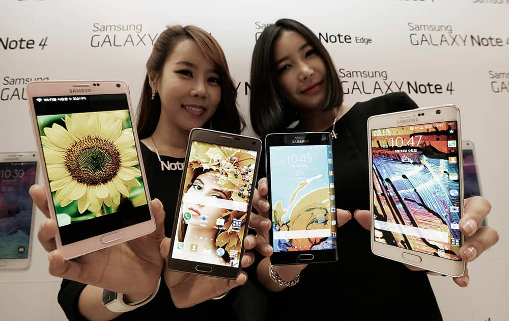 Models pose with Samsung Electronics Co.'s latest Galaxy Note 4 and Galaxy Note Edge smartphones as they are unveiled in Seoul, South Korea.