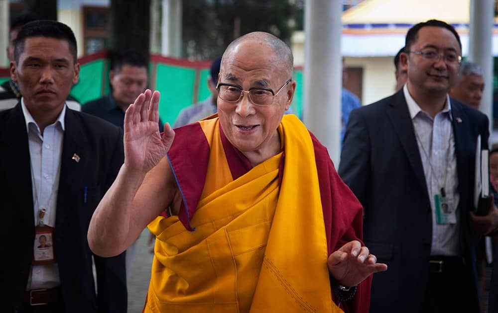 Tibetan spiritual leader the Dalai Lama, center, greets devotees as he arrives at the Tsuglakhang temple for a religious talk in Dharmsala.