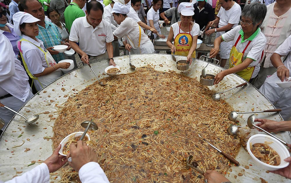 Thai chefs serve vegetarian food from a giant cooking bowl for people attending the vegetarian festival celebration in Chiang Mai province, northern Thailand.