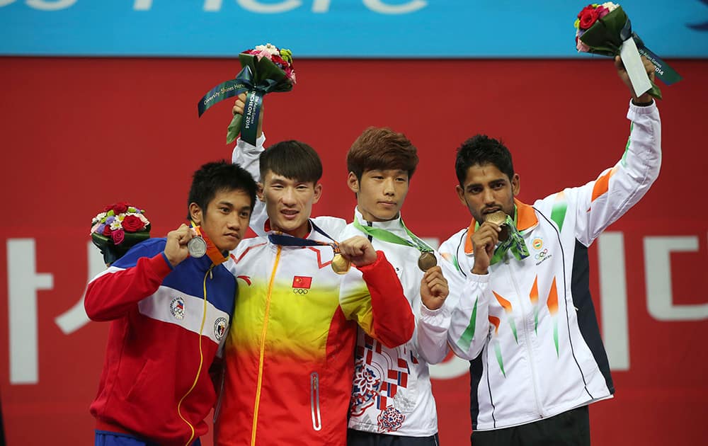 Medalists of the men's 60kg Wushu Sanda competition standing left to right; Philippines Jean Claude Saclag, silver, China's Kong Hongxing, gold, South Korea's Kang Yeong-sik, bronze, and India's Narender Grewal display their medals at the 17th Asian Games in Incheon, South Korea. 