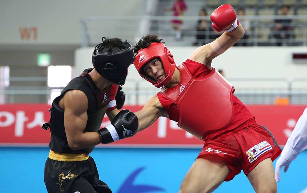 South Korea's Yoo Sang-hoon, right, strikes China's Zhang Kun during the men's 70kg Wushu Sanda competition at the 17th Asian Games in Incheon, Korea.