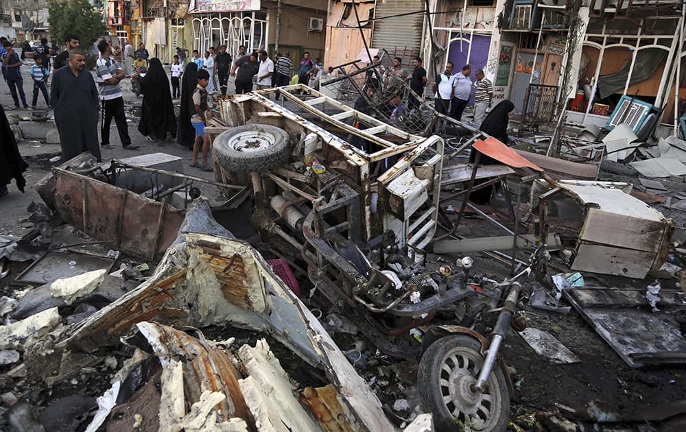 Iraqis gather at the site of a Tuesday night car bomb attack on a busy commercial street in the Shiite stronghold of Sadr City, Baghdad.