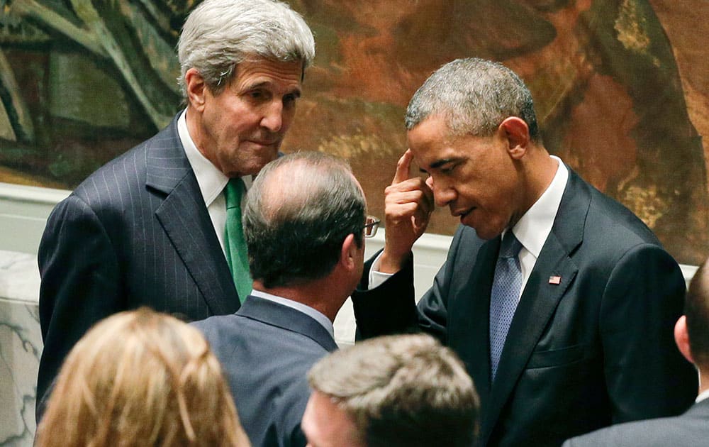 President Barack Obama, right, and Secretary of State John Kerry, left, talk with French president Nicolas Hollande before a UN Security Council meeting, at the United Nations. Members of the Security Council were expected to adopt a resolution that would require all countries to prevent the recruitment and transport of would-be foreign fighters preparing to join terrorist groups such as the Islamic State group.