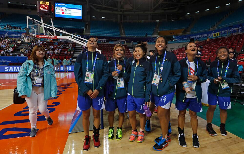 Nepal team members leave the basketball court as Qatar team did not turn up for the women's preliminary round basketball match at the 17th Asian Games in Incheon, South Korea. Qatar's delegation chief says the women's basketball team has withdrawn from the Asian Games after organizers refused to let players wear hijabs in competition.