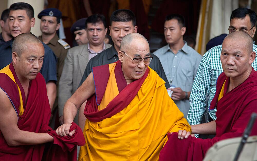 Tibetan spiritual leader the Dalai Lama, is helped by attendant monks as he leaves after his religious talk at the Tsuglakhang temple in Dharmsala.
